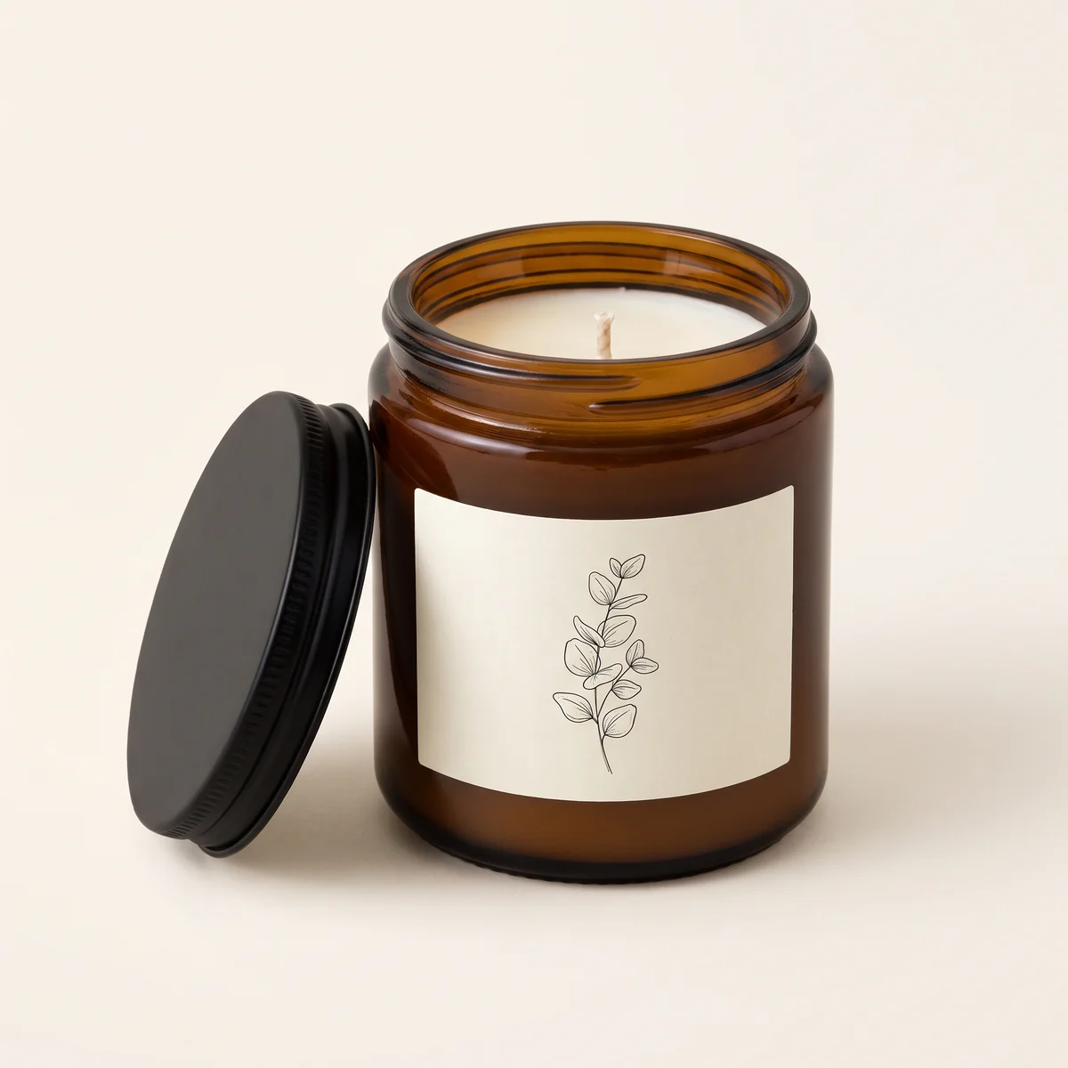The reference photo: an unbranded amber glass candle jar with a black lid and a cream botanical label
